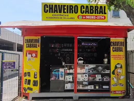 Fachada do quiosque do Chaveiro Cabral, com a placa amarela e o telefone (31) 98282-2774, na entrada do Supermercado BH